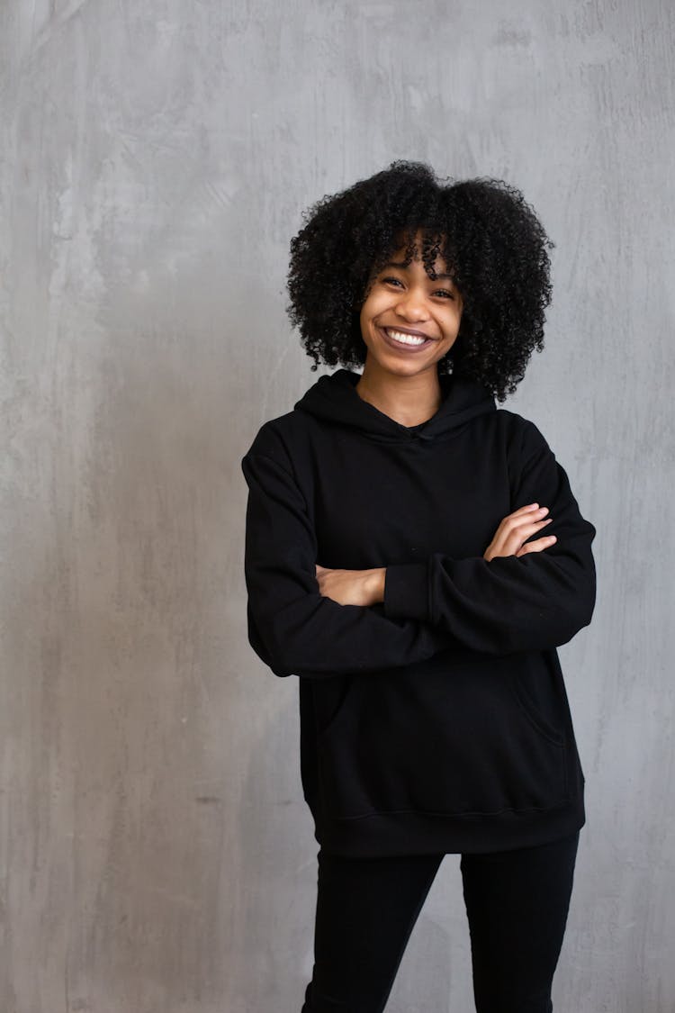 Cheerful Black Woman Wearing Casual Wear Standing Against Gray Wall