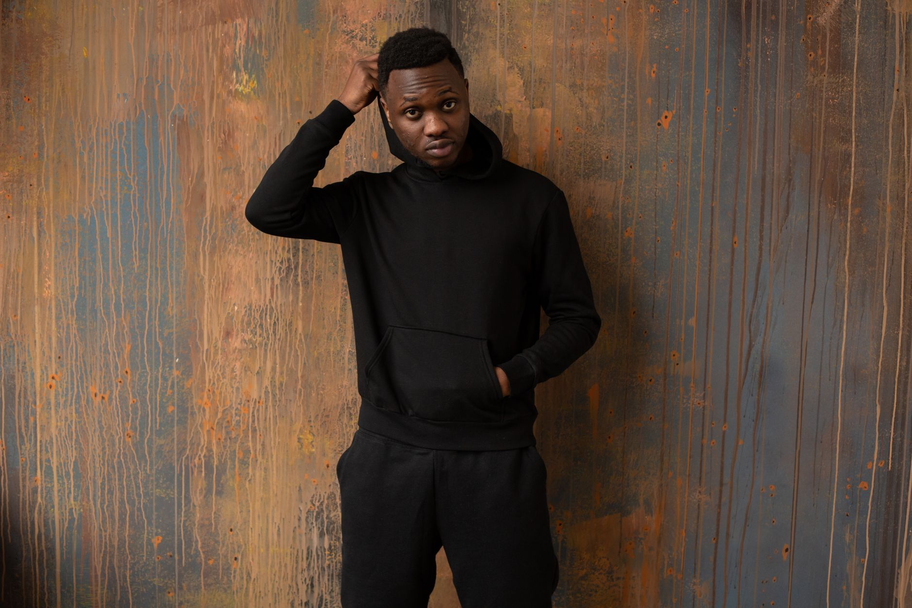 Homme en sweat capuche noir porté avec jogging coordonné style streetwear premium
