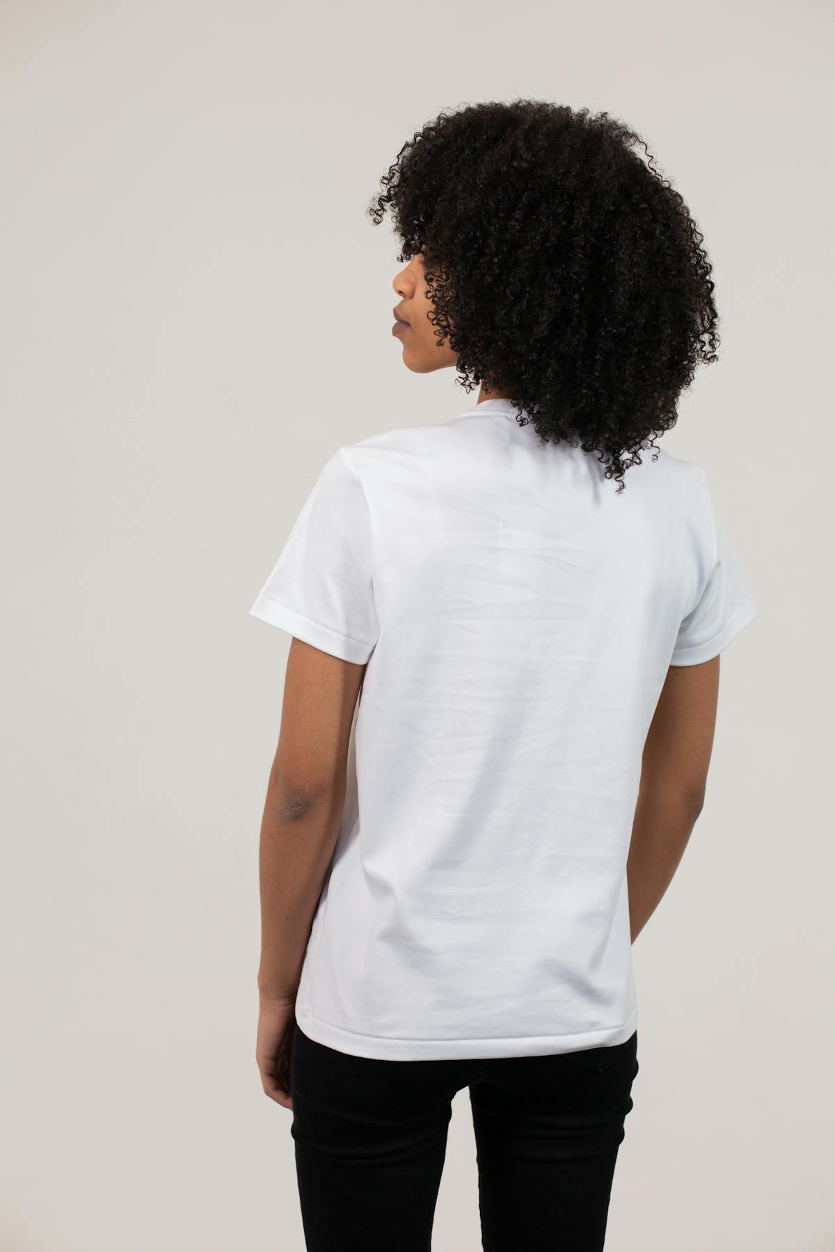 Person walking in the city wearing athleisure outfit with trench coat and sneakers