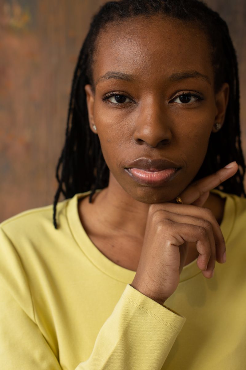 Designer in a yellow top looking at the camera