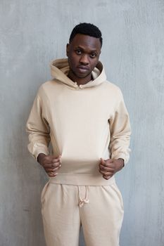 Self confident black man in beige hoodie