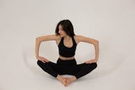 Fit woman sitting in butterfly pose and pressing on legs