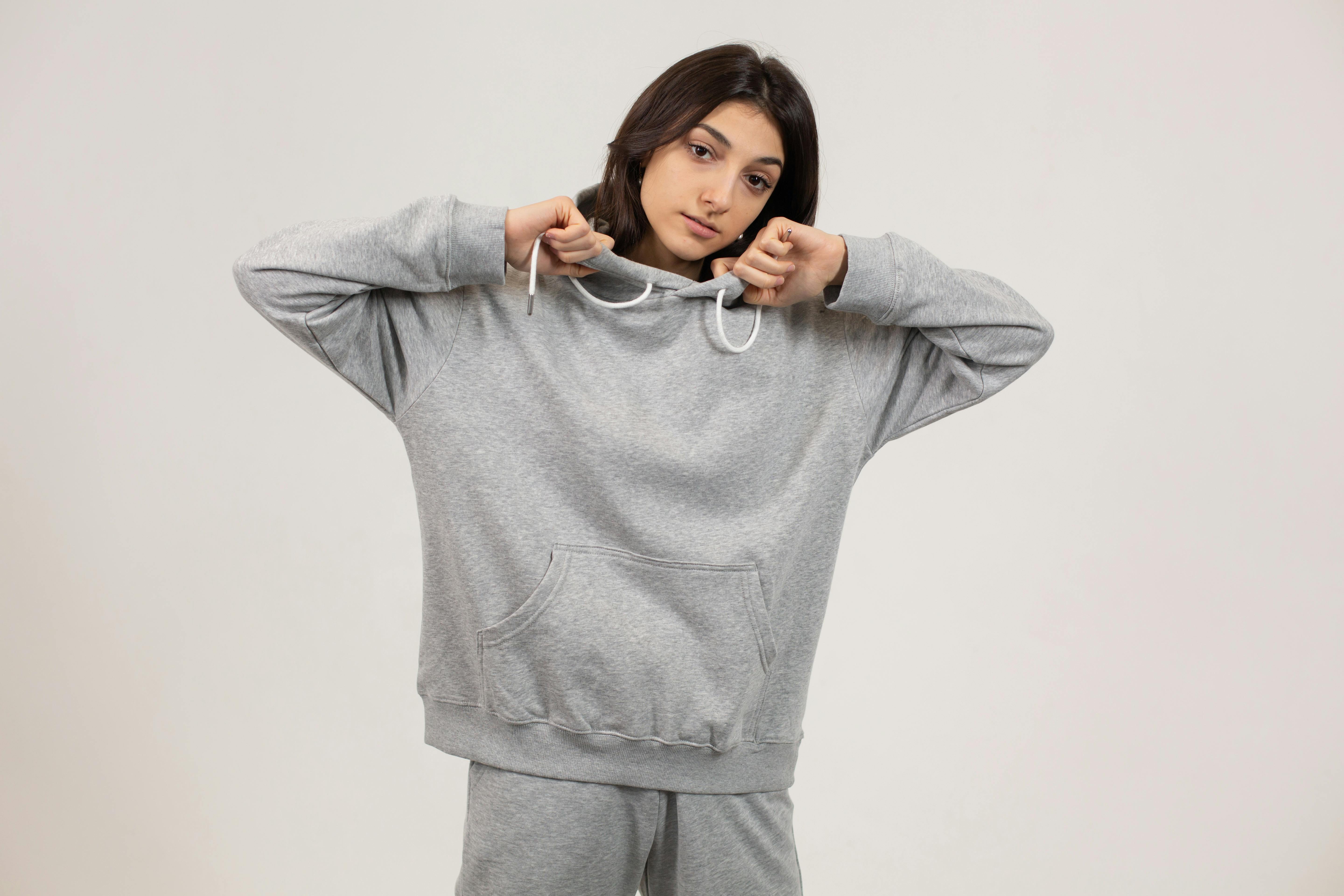young woman with hand on hoodie in studio