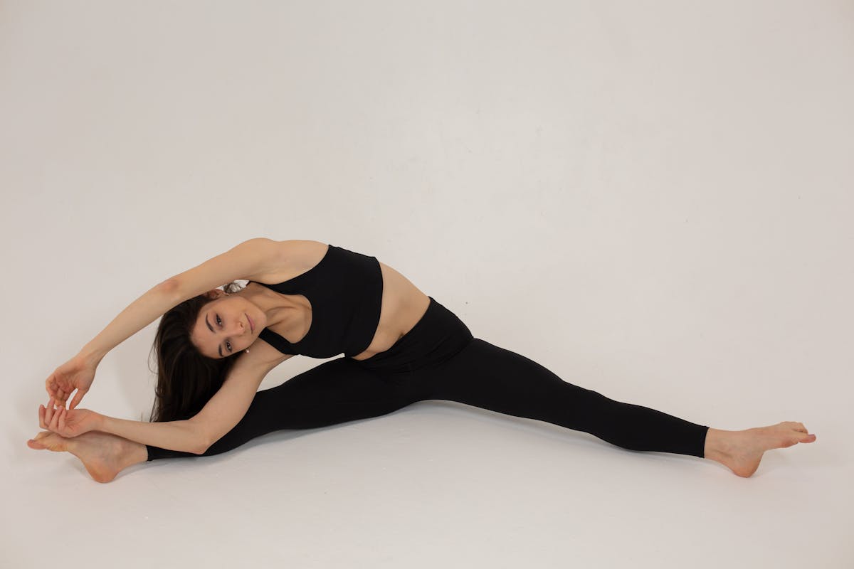 Flexible woman stretching body during training
