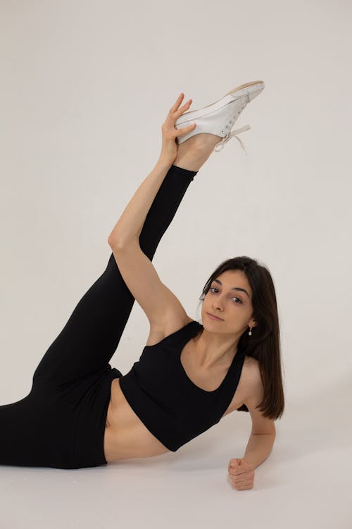 Flexible woman doing exercise for stretching in studio