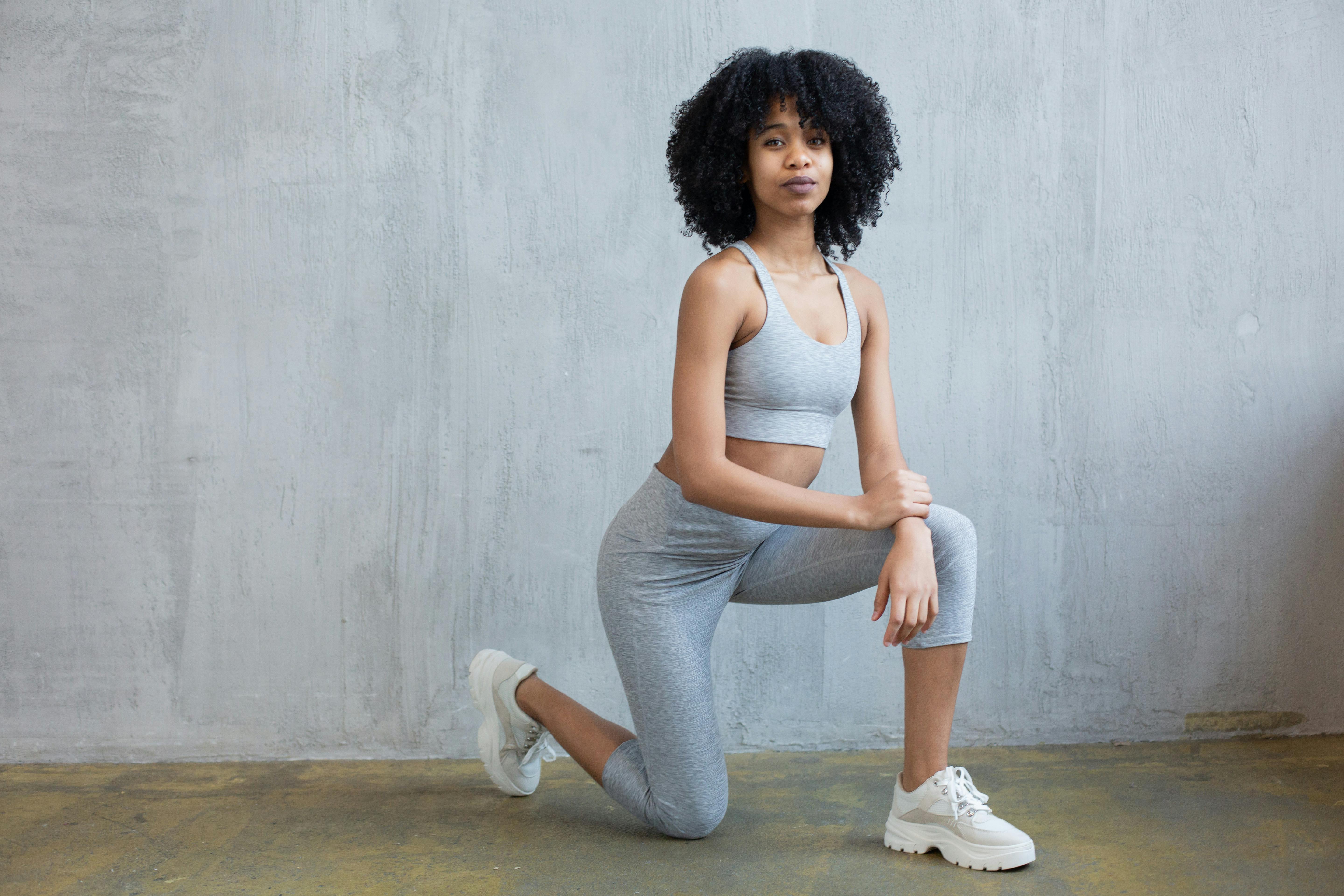 Black woman in sportswear doing lunge exercise · Free Stock Photo