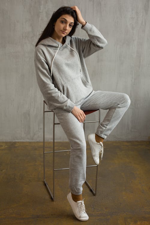 Stylish young woman in trendy sportswear in studio