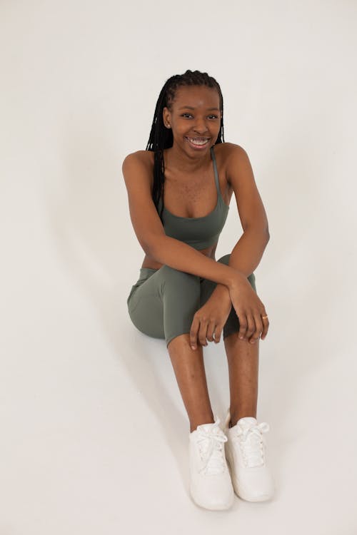 Free Smiling black woman sitting on white floor Stock Photo