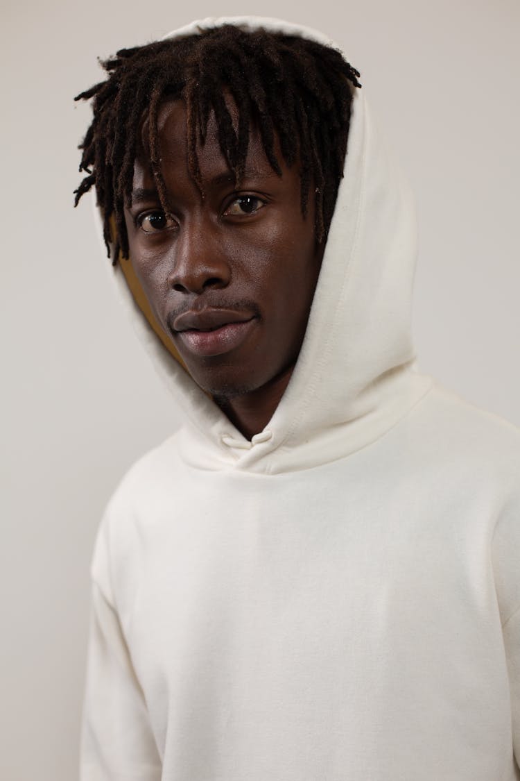 Black Man In Hoodie Near White Wall