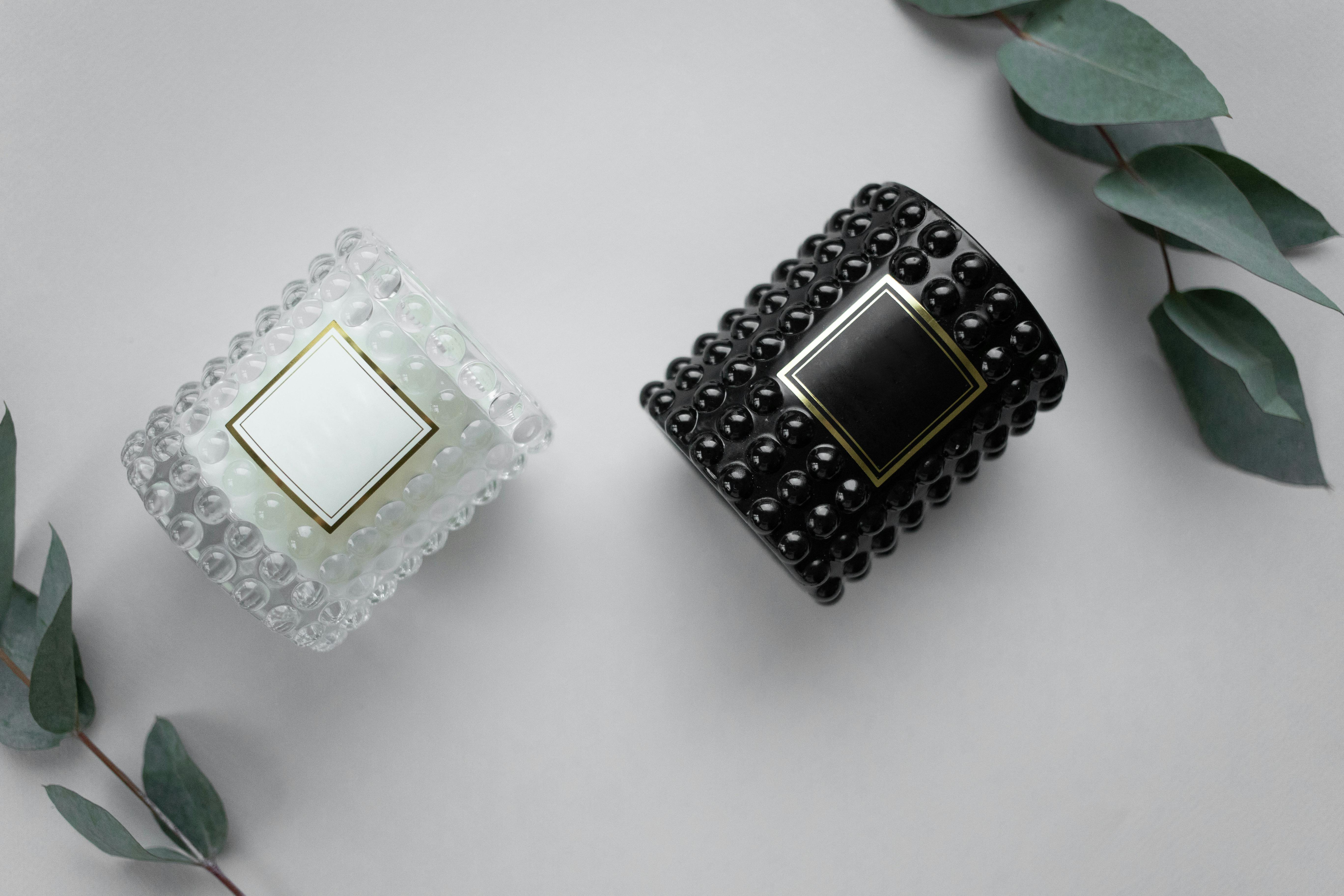 Stylish product photography of black and white candles with eucalyptus on a white background.