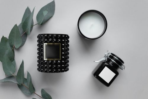 Free Elegant set of black candle, jar, and eucalyptus leaves on a gray background. Stock Photo