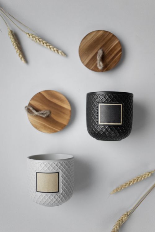 Free Artistic flat lay of black and white ceramic cups with wooden lids and wheat elements. Stock Photo