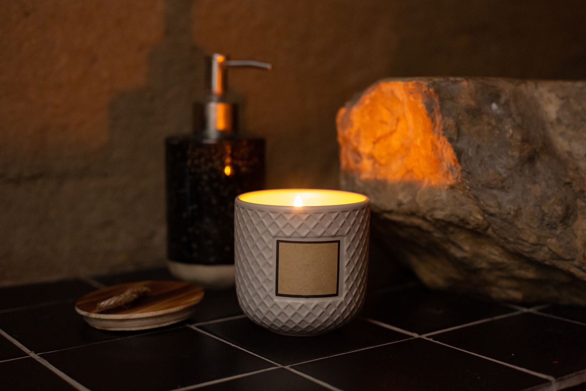 A calming scene featuring a burning candle and ceramic decor in a warm, illuminated setting.