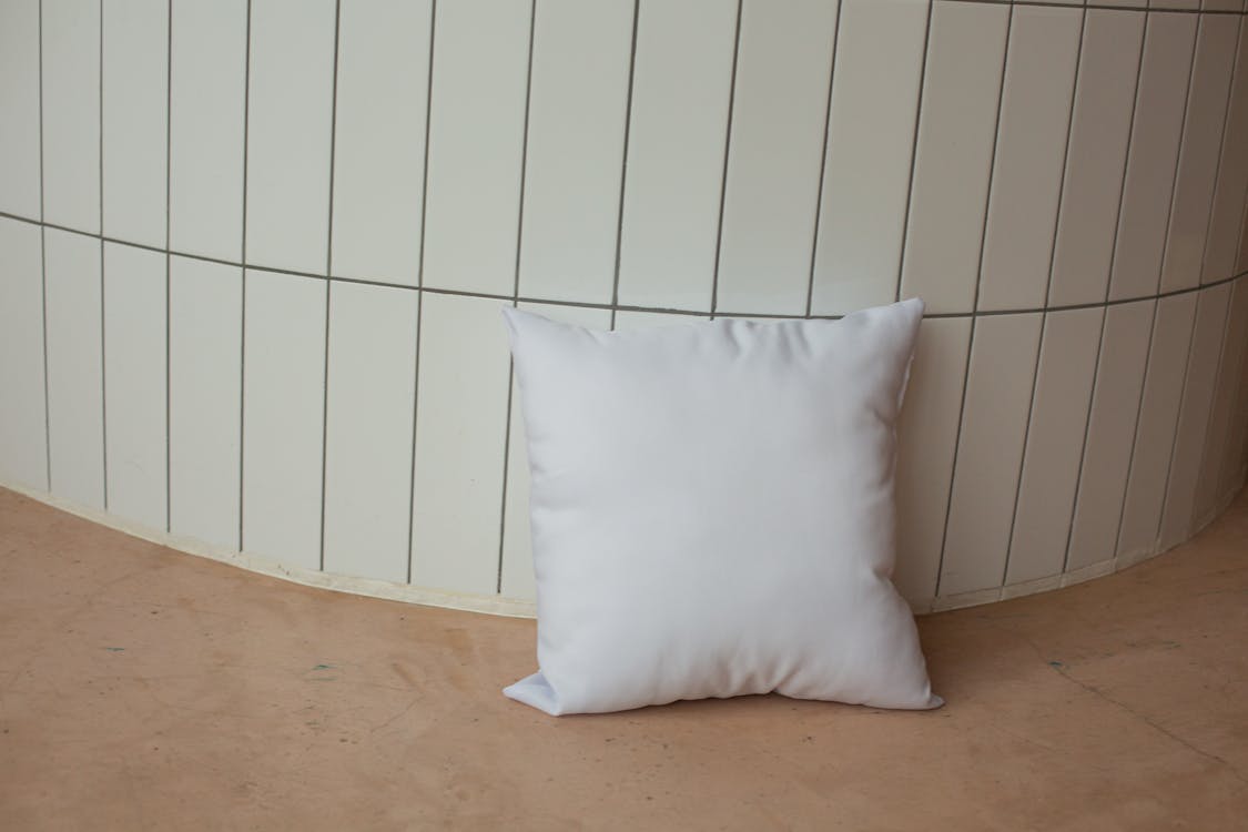 White Throw Pillow on the Ground
