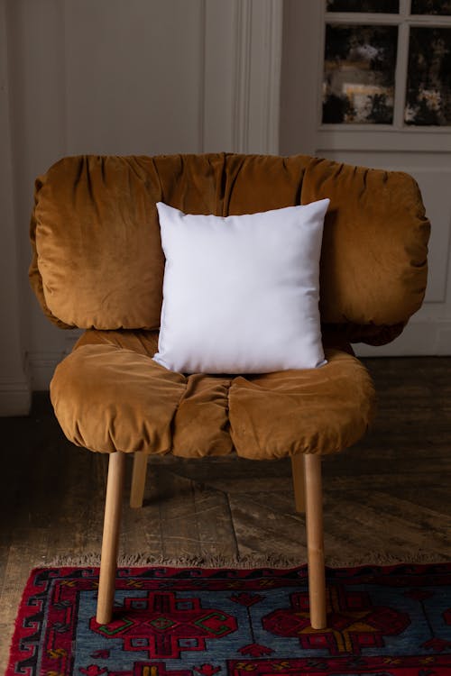 Brown Chair with a White Throw Pillow