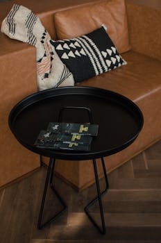 Contemporary living room featuring a sleek black table, brochure display, and cozy leather couch.