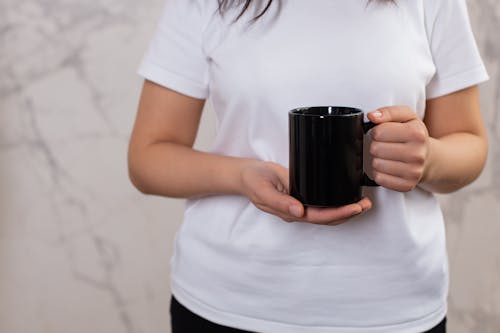 Person Holding a Black Mug