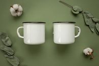 2 White Ceramic Mugs on Green Table