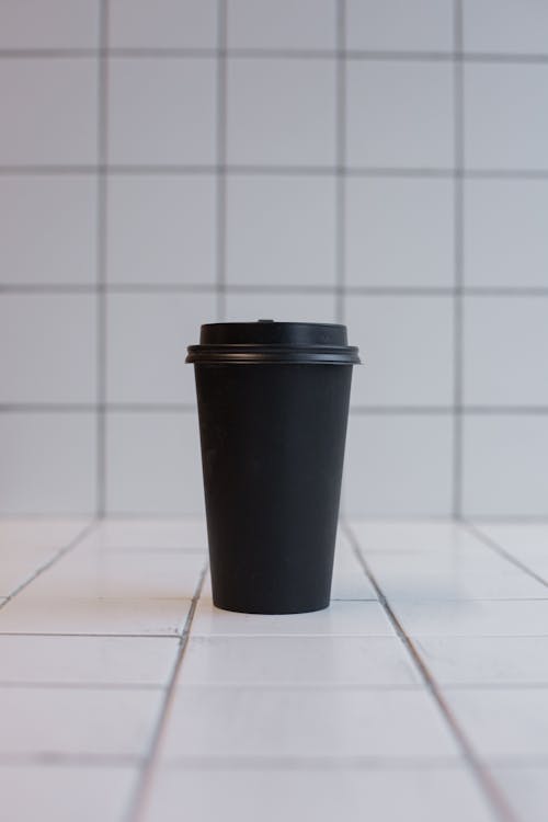 Black Plastic Cup on White Tiles