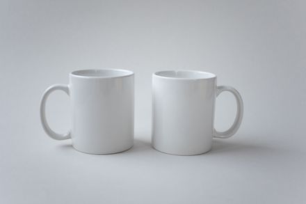 Pair of plain white stoneware mugs on a soft grey surface — photo by KATRIN BOLOVTSOVA on Pexels