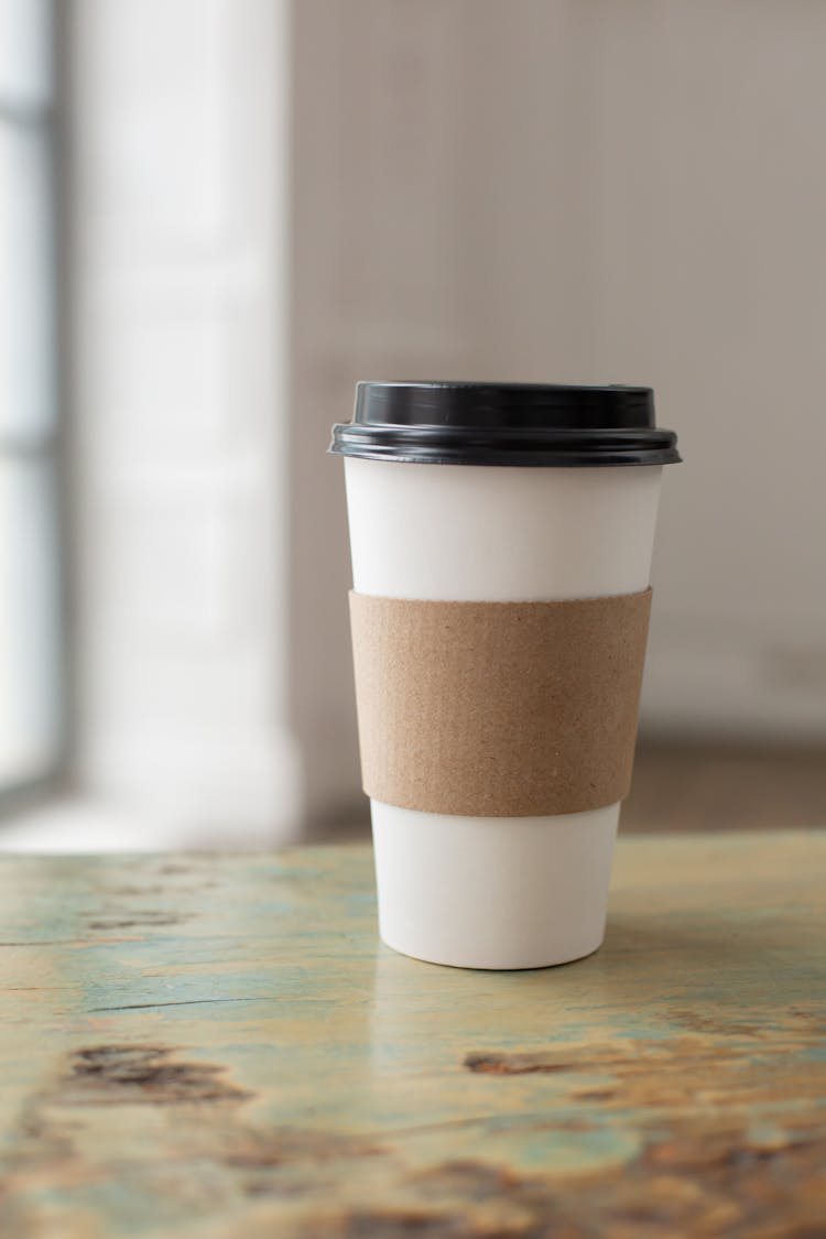 Cup With Black Lid On A Wooden Surface