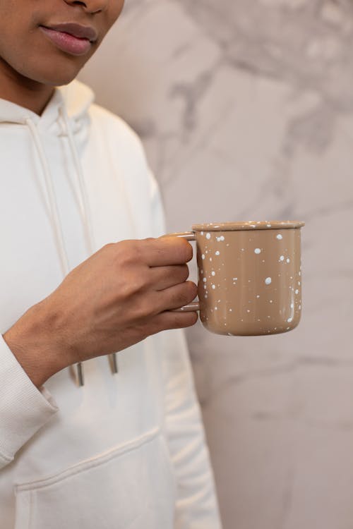 Free Person in White Hoodie Holding Brown Cup Stock Photo