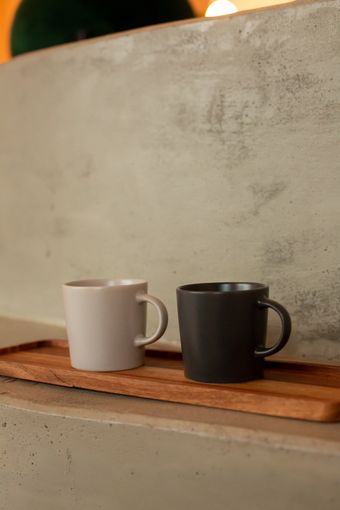 Two stoneware mugs on a wooden board — photo by KATRIN  BOLOVTSOVA on Pexels