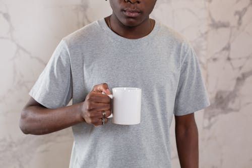 Person Holding a Plain White Mug