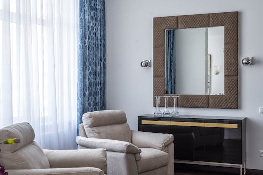 Interior of modern living room with comfy soft armchairs and square mirror in stylish apartment