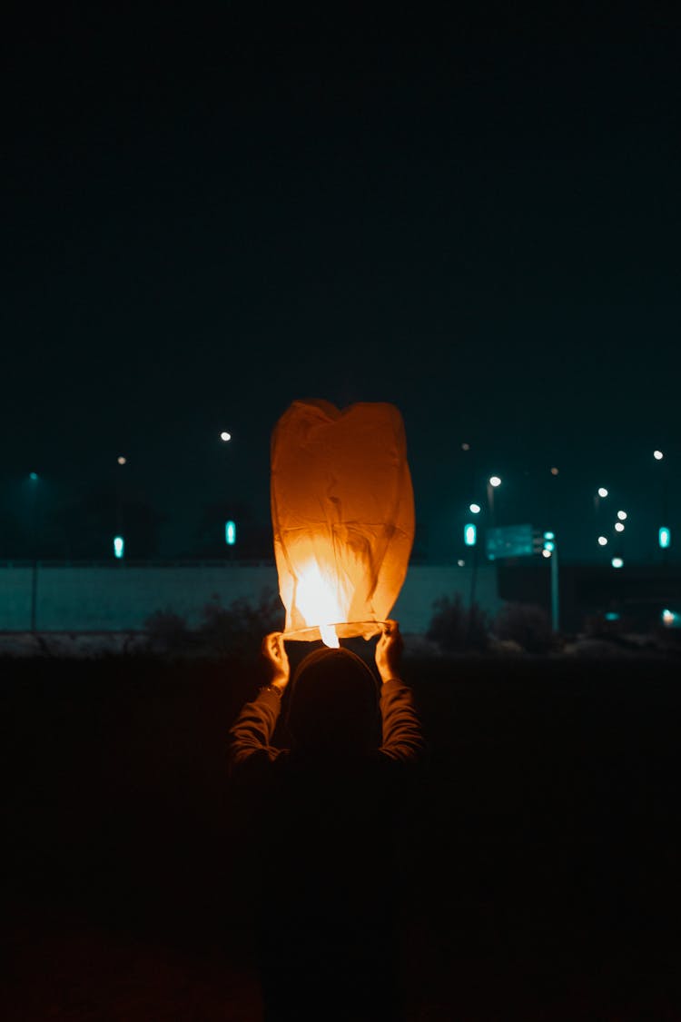 A Person Holding Flying Lantern