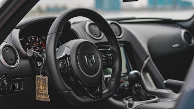 Close-up view of a luxury car interior showcasing the steering wheel, gearshift, and dashboard features.