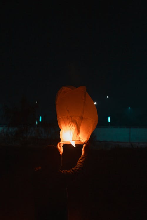 Free A Person Holding a Sky Lantern Stock Photo