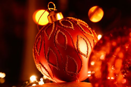 Free Close-up of a beautifully detailed red Christmas ornament with a warm bokeh effect creating a festive atmosphere. Stock Photo