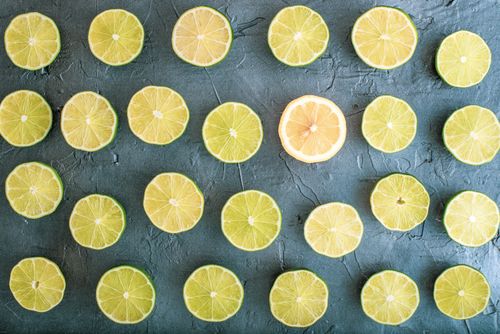Free Top view of lime and lemon slices arranged in a pattern on a textured gray background. Stock Photo