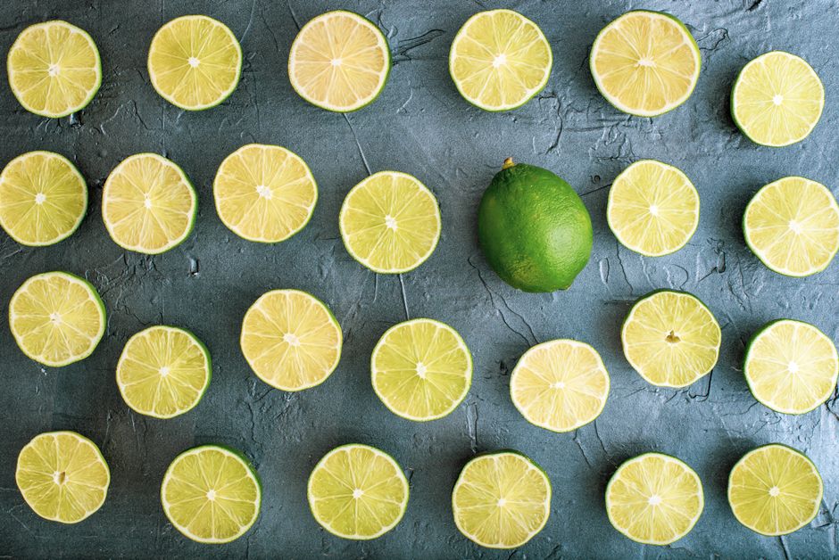 Top view of lime slices arranged on a gray textured background.