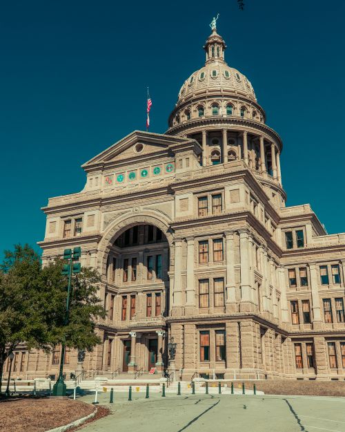 Free Historical Texas State Capitol against a clear blue sky on a sunny day in Austin, TX. Stock Photo