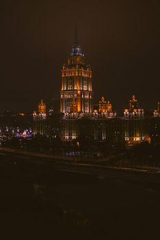 A stunning view of a palatial skyscraper beautifully illuminated against the night sky, showcasing urban architecture.