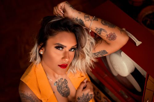 Free From above of young attractive female with tattoos and piercing looking at camera Stock Photo