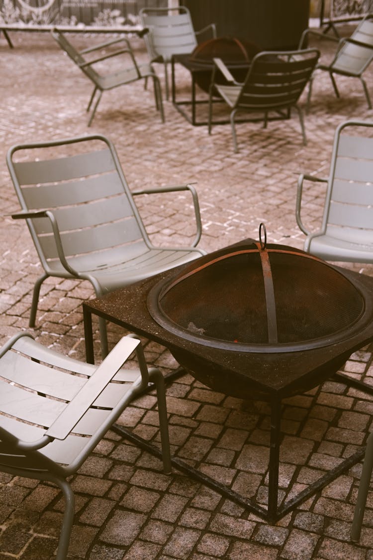 A Fire Pit And Chairs On A Patio