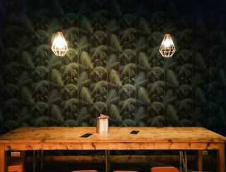 Glass pendant lamps glowing above a long table — photo by Ingo Joseph on Pexels