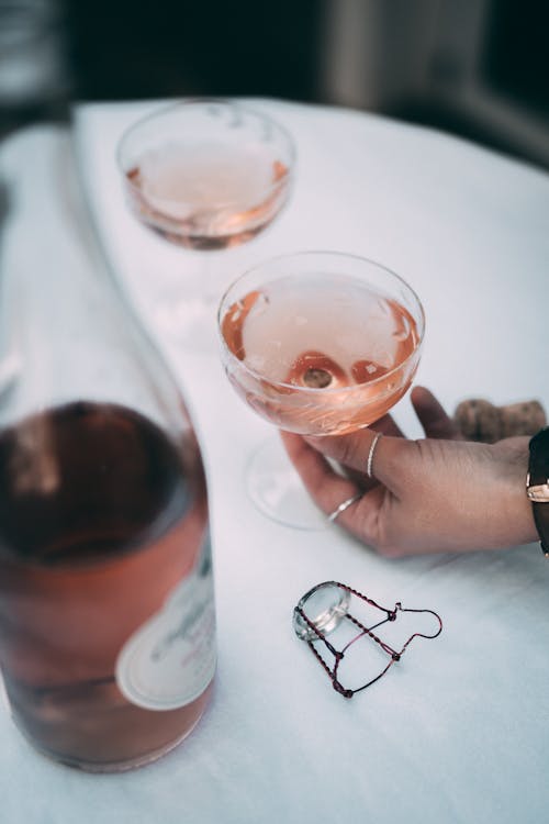 A Hand Getting the Glass of Champagne on the Table