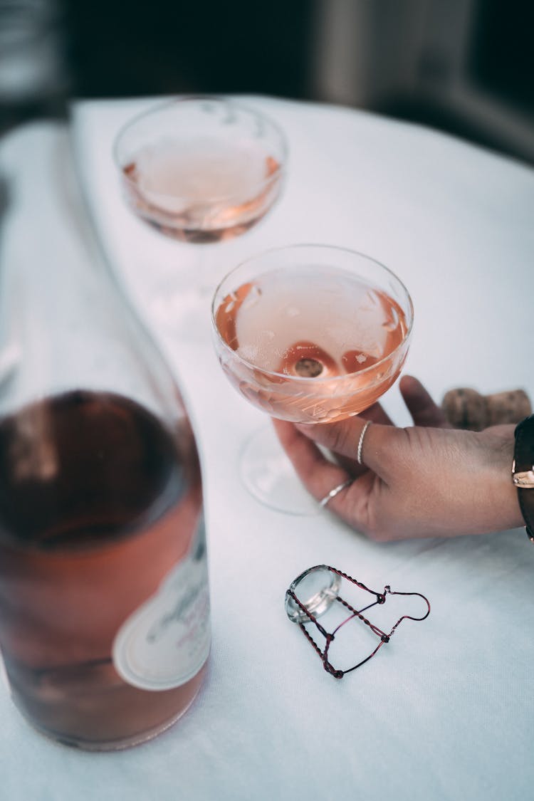 A Hand Getting The Glass Of Champagne On The Table