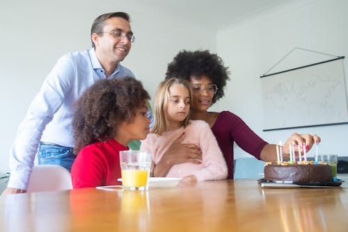 Free A Woman Lighting Candles on a Birthday Cake for her Daughter Stock Photo