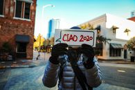 A Person in a Puffer Jacket a Holding a Placard in the Street