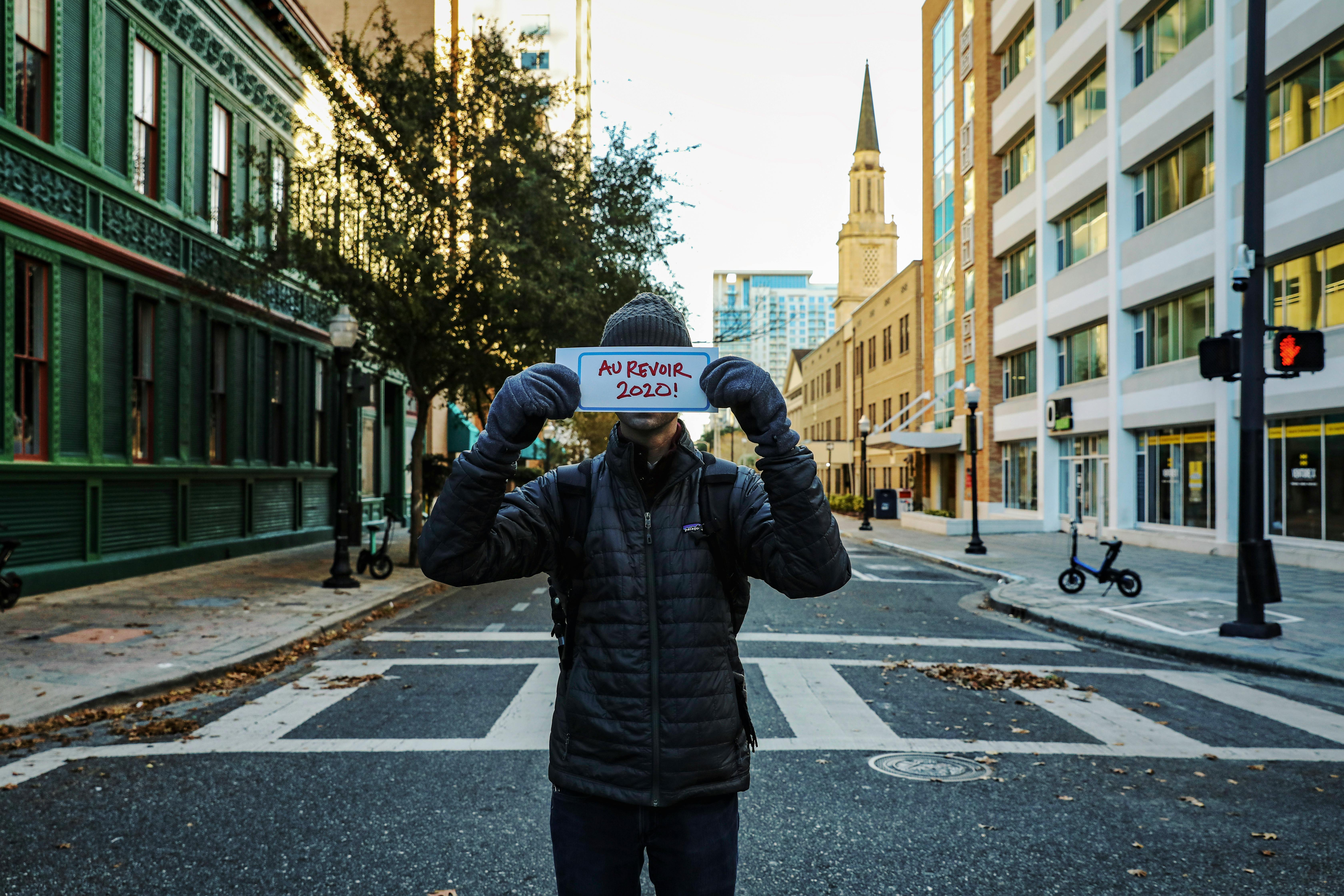 a person in a puffer jacket a holding a placard in the street