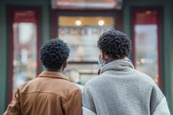 Anonymous black men standing near showcase