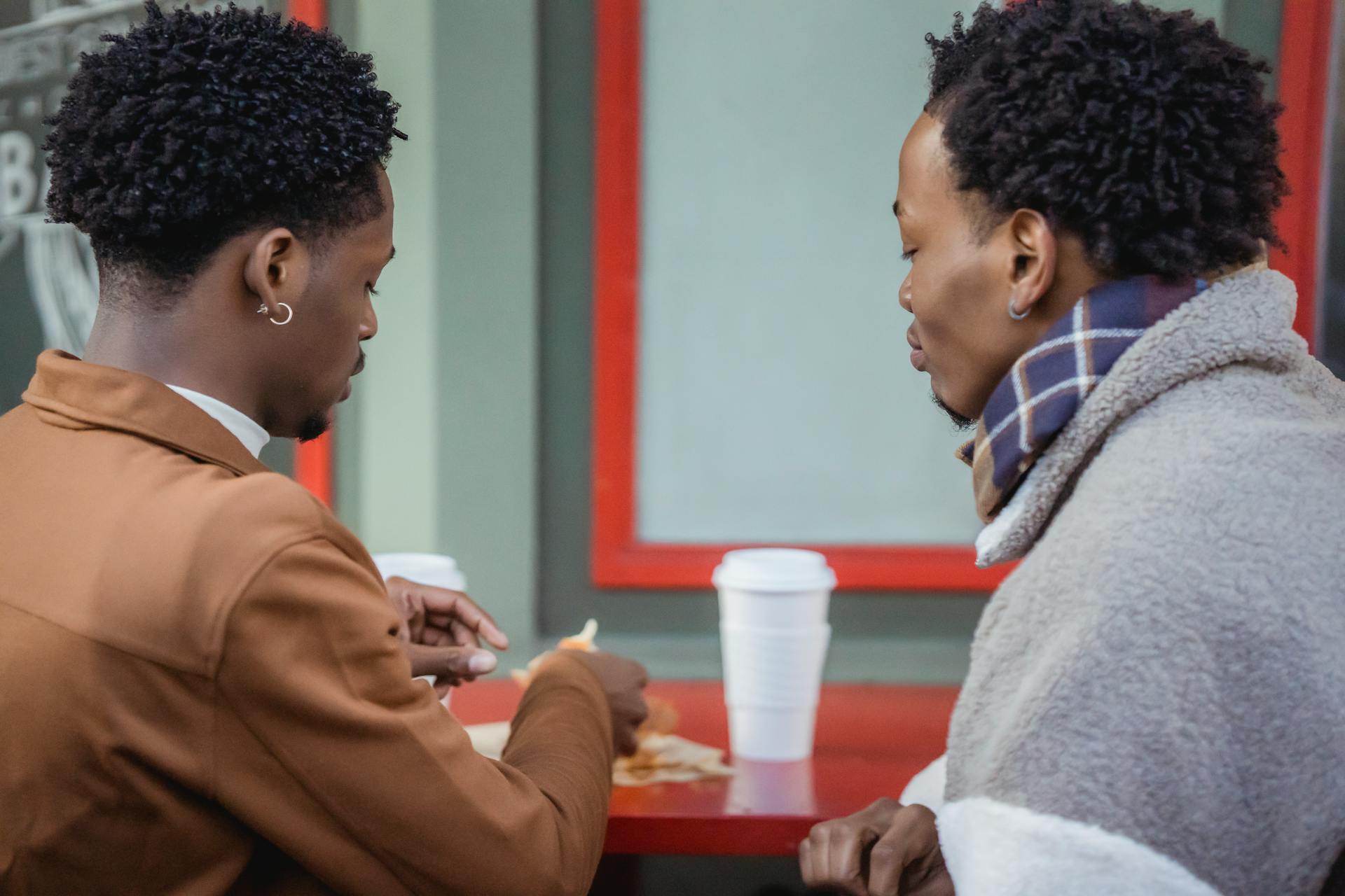 Black homosexual couple eating on street