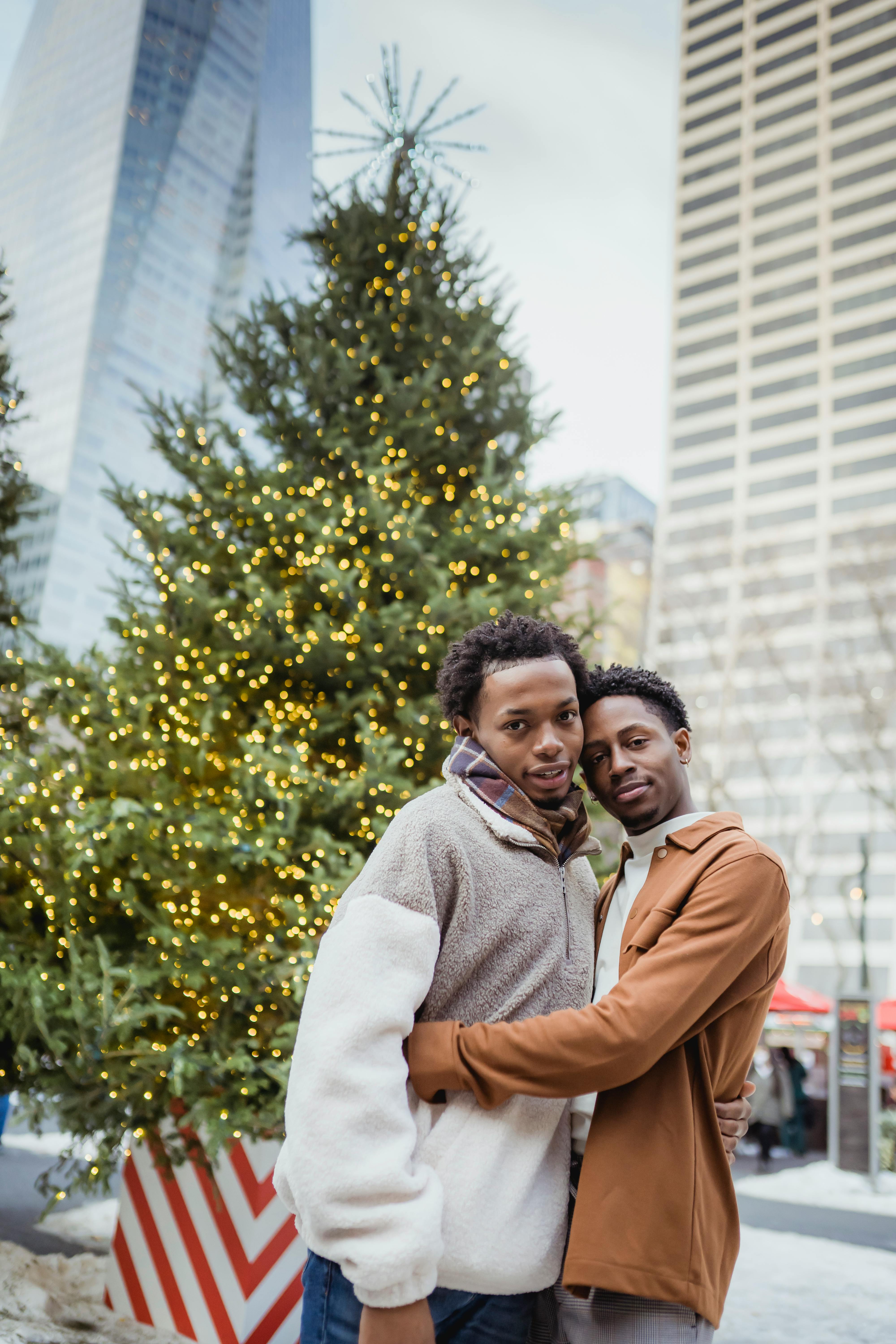 loving young homosexual men hugging on city street during xmas holidays