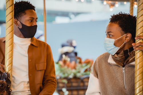 Young black male millennials riding on merry go round