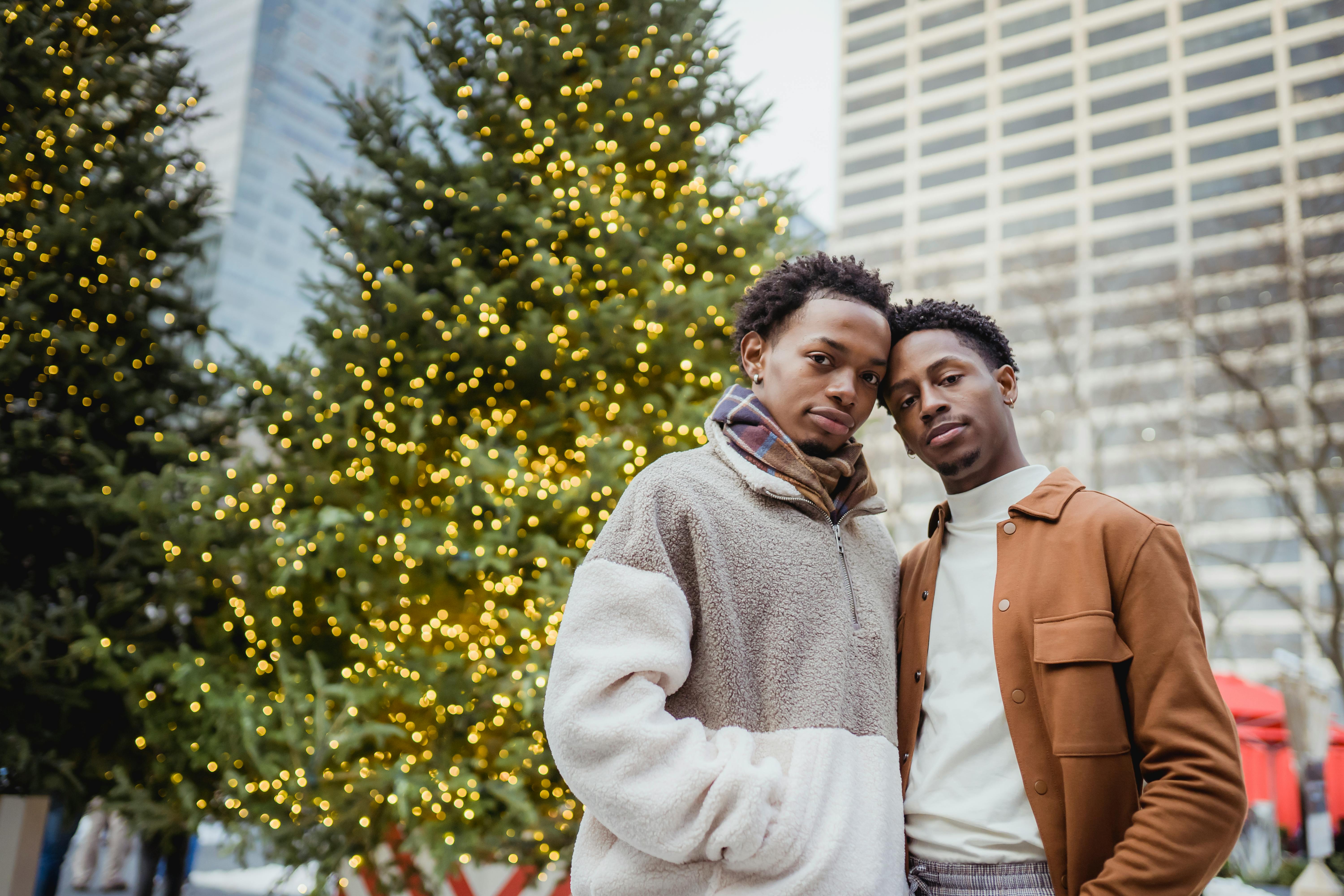 beloved young black homosexual men cuddling on street and looking at camera